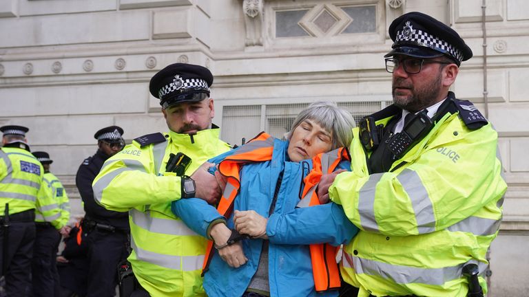 Officers from the Metropolitan Police remove a Just Stop Oil protester who was detained whilst blocking Whitehall during a protest in central London. Picture date: Monday November 6, 2023.