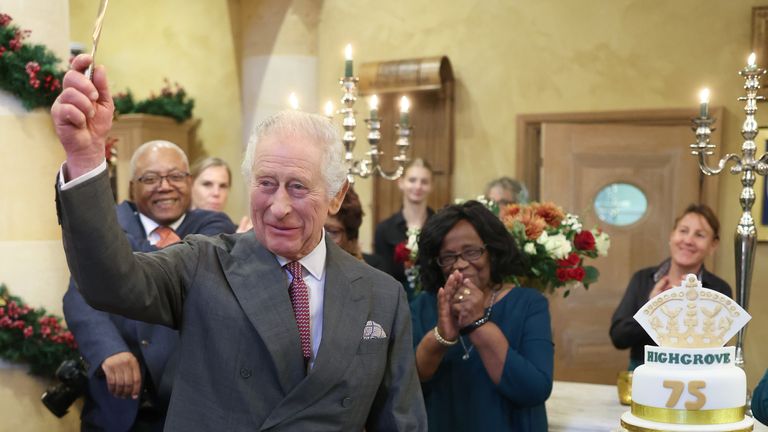 King Charles III holds knife in the air after cutting his 75th birthday cake in Highgrove 