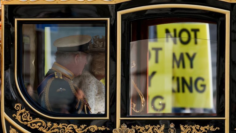 Britain's King Charles and Queen Camilla pass protesters as they travel by carriage to the State Opening of Parliament in London, Britain November 7, 2023. REUTERS/Hollie Adams