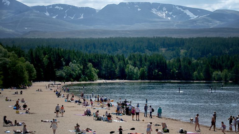The last few patches of snow remain on the Cairngorms as people enjoy the hot weather on the highest beach in the UK at Loch Morlich near Aviemore, as Britons could see the hottest day of the year this Bank Holiday Monday.