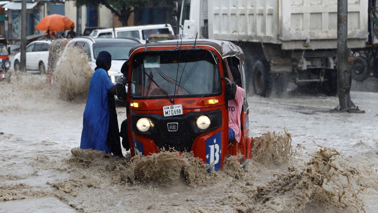 A woman disembarks from a rickshaw taxi in the flooded KM5 street following heavy rains in Mogadishu, Somalia November 8, 2023 REUTERS/Feisal Omar