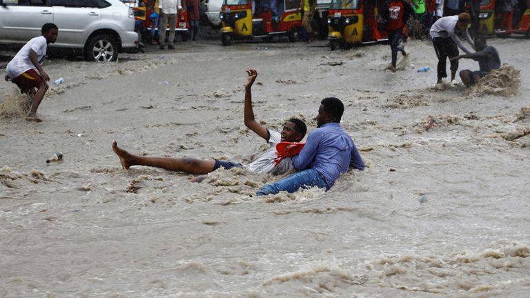A man attempts to rescue a boy from raging flood waters following heavy rains in Mogadishu, Somalia November 9, 2023. REUTERS/Feisal Omar
