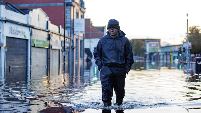 A walks through flood water on Market Street in Downpatrick, Northern Ireland