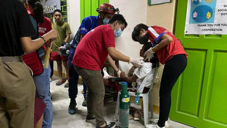 Red Cross volunteers help people affected by the earthquake Pic: Philippine Red Cross via AP