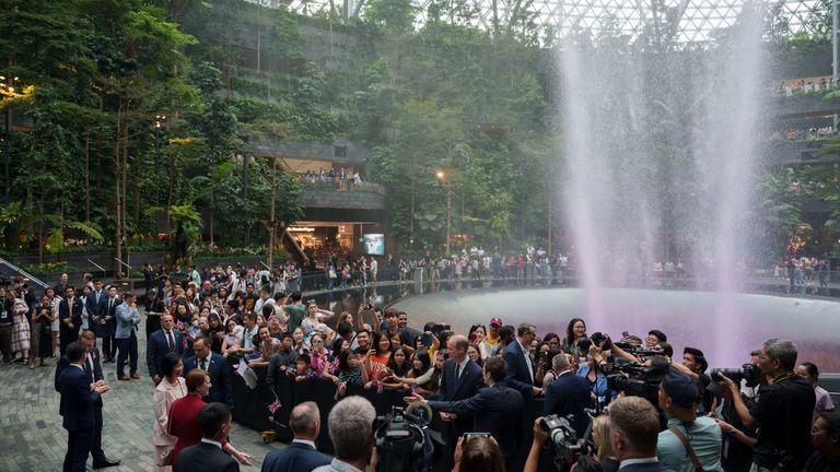 Prince William, seen in the middle of the crowd, travelled without Kate to Singapore. Pic: AP