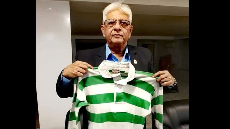 Rashid Ahmed, Mohammed Salim's son, holding his dad's green and white jersey.