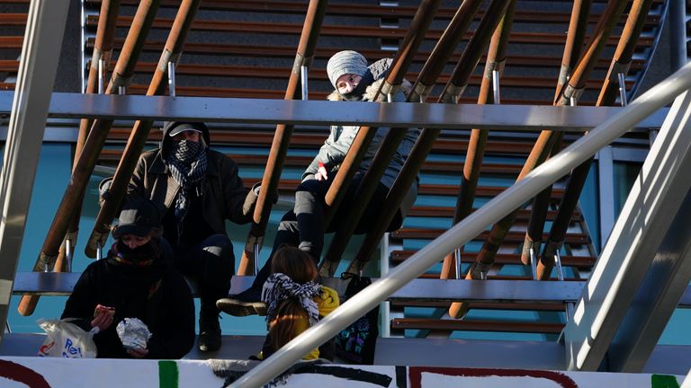 Pro-Palestinian protesters on the roof of the Scottish Parliament in Holyrood, Edinburgh, after hanging a banner and the Palestinian flag. The group of five climbed up the awning outside the main entrance on Thursday morning, unfurling a banner which reads "Stop arming Israel". Police have cordoned off the area underneath but business in the Parliament is continuing. Picture date: Thursday November 9, 2023.