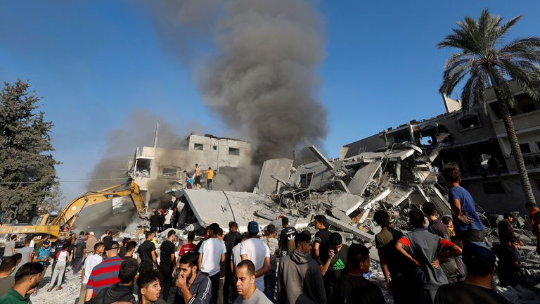 Smoke rises as Palestinians search for casualties at the site of Israeli strikes on a residential building , in Khan Younis in the southern Gaza Strip 