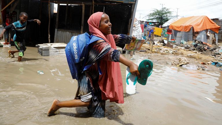 An internally displaced Somali school girl wades through flood waters outside their makeshift shelter following heavy rains at the Al Hidaya camp for the internally displaced people on the outskirts of Mogadishu, Somalia November 6, 2023 REUTERS/Feisal Omar