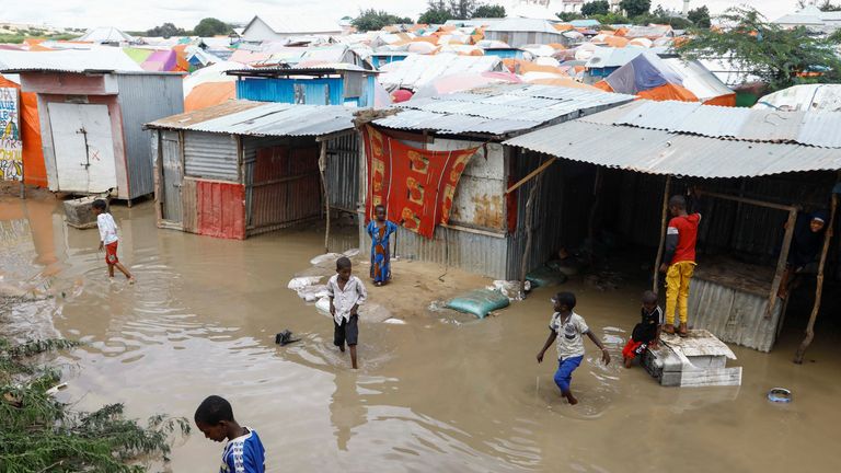 Internally displaced Somali children wade through flood waters outside their makeshift shelters following heavy rains at the Al Hidaya camp for the internally displaced people on the outskirts of Mogadishu, Somalia November 6, 2023 REUTERS/Feisal Omar