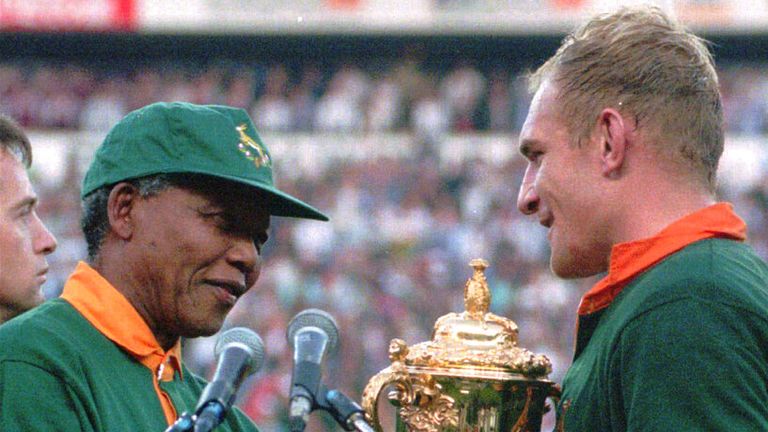 South African president Nelson Mandela passing Springboks captain Francios Pienaar the World Cup trophy in 1995