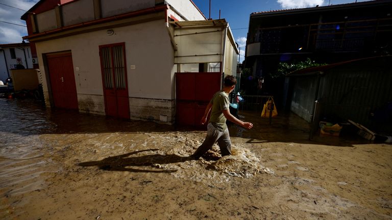 A man walks on a flooded street in Campi Bisenzio