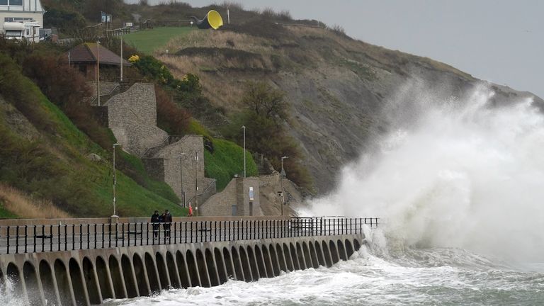 Waves crash over the harbour arm in Folkestone, Kent