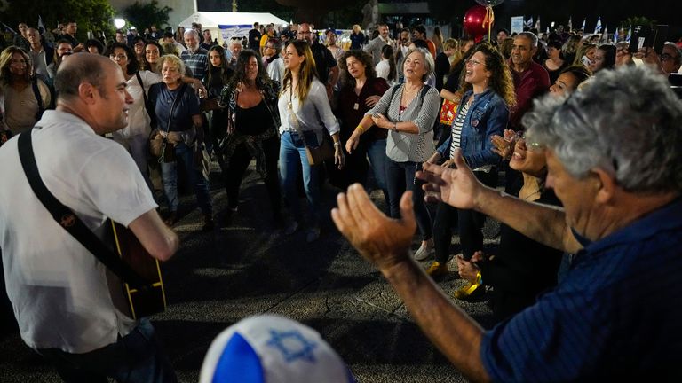 People in Tel Aviv, Israel, react after hearing the news of the release of 13 Israeli hostages. Pic: AP