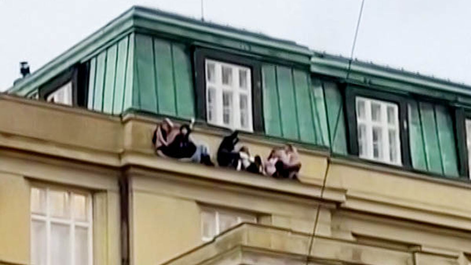 Prague shooting: Footage shows people cowering on ledge of university building as police hunt gunman