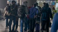 Journalists try to interview Indian passengers, who arrived in an unmarked Legend Airlines A340 from Vatry Airport in France, at the Chhatrapati Shivaji Maharaj International Airport in Mumbai, India, Tuesday, Dec. 26, 2023. A charter plane that was grounded in France for a human trafficking investigation arrived in India with 276 Indians aboard early Tuesday, authorities said. The passengers had been heading to Nicaragua but were instead blocked inside the Vatry Airport for four days in an exceptional holiday ordeal. (AP Photo/Rafiq Maqbool)