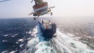 File:  Houthi military helicopter flies over the Galaxy Leader cargo ship in the Red Sea in this photo released November 20, 2023 