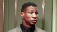 Jonathan Majors, left, enters a courtroom at the Manhattan criminal courts in New York, Monday, Dec. 18, 2023. The actor is accused of assaulting his then-girlfriend as the two struggled over a phone in the back seat of a chauffeured car. (AP Photo/Seth Wenig)
