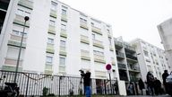 People stand outside of the ground floor flat where the bodies of a woman and her four children where discovered in Meaux, northeast of Paris, France