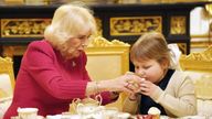 Queen Camilla offers seven-year-old Olivia Taylor from Sidcup her very first cup of tea during a visit to Windsor Castle