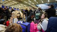 Passengers sit on the floor of the concourse at the entrance to Eurostar in St Pancras International station