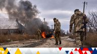 FILE - In this photo provided by the Ukrainian 10th Mountain Assault Brigade "Edelweiss", Ukrainian soldiers pass by a volunteer bus burning after a Russian drone hit it near Bakhmut, Donetsk region, Ukraine, Thursday, Nov. 23, 2023. 