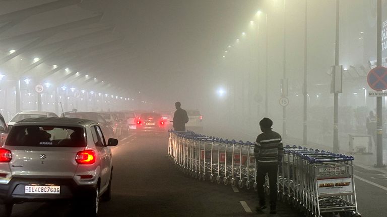 Airport staff take luggage trollies back inside the terminal amidst early morning fog at the Indira Gandhi International Airport, in New Delhi, India
Pic:AP