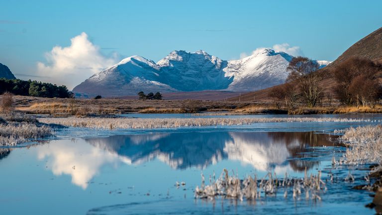 The snow-covered peak of Beinn Eighe and the mountains of Torridon are reflected in Loch Droma near Ullapool, Wester Ross. Picture date: Sunday December 3, 2023.