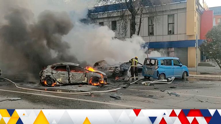 In this photo taken from video released by Russia Emergency Situations Ministry telegram channel on Saturday, Dec. 30, 2023, firefighters extinguish burning cars after shelling in Belgorod, Russia. (Russia Emergency Situations Ministry telegram channel via AP)
