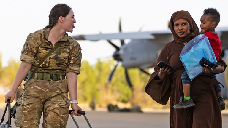 A member of the RAF evacuation team, is seen here in Sudan amusing a child as she leads them onto a waiting aircraft bound for Cyprus...The final days of evacuations from Wadi Seidna Air Base in Sudan, sees the last evacuees and military personnel making their way to board an RAF aircraft bound for Cyprus (29/04/2023). ..The UK government assisted by the British Military has evacuated British Citizens from Sudan...RAF flights are continuing between Wadi Seidna airport in Sudan to Larnaca International Airport, following three evacuation flights that took place late overnight between Tuesday 25 April and Wednesday 26 April...The Ministry of Defence has been working to support the Foreign, Commonwealth & Development Office in evacuating civilian UK nationals from the airport...The operation involved more than 1,200 personnel from 16 Air Assault Brigade, the Royal Marines and the Royal Air Force..