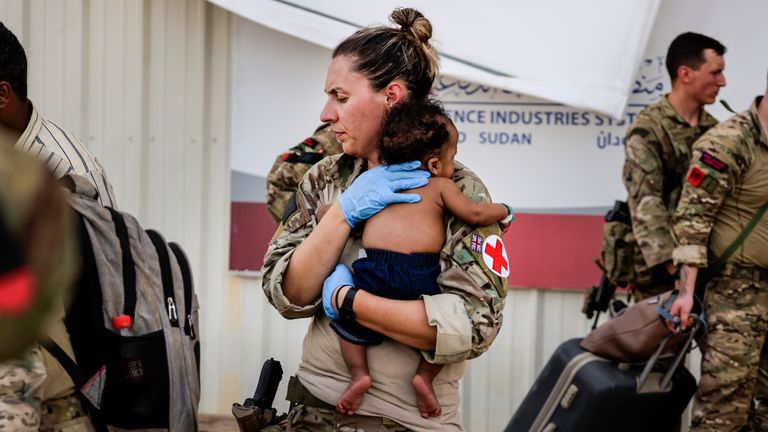 Image of an Army paramedic comforting a baby following treatment, whilst at Wadi Seidna Air Base in Sudan (27/04/2023)...RAF flights are continuing between Wadi Seidna airport in Sudan to Larnaca International Airport, following three evacuation flights that took place late overnight between Tuesday 25 April and Wednesday 26 April...The UK government assisted by the British Military has evacuated British Citizens from Sudan...The Ministry of Defence has been working to support the Foreign, Commonwealth & Development Office in evacuating civilian UK nationals from the airport...The operation involved more than 1,200 personnel from 16 Air Assault Brigade, the Royal Marines and the Royal Air Force...