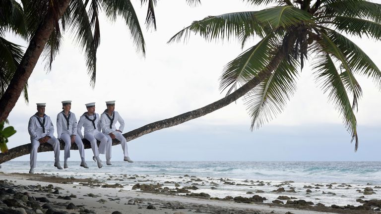 Image of Royal Navy personnel from HMS Tamar are seen here on a beach in Diego Garcia...Sailors from HMS Tamar wore there tropical 1s uniform to Cannon Corner beach in Diego Garcia. Royal Navy Photographer, Leading Photographer Chris Sellars got his inspiration from an image taken on the island during the end of World War two. The original image had British Military personnel relaxing in a palm tree awaiting the announcement of the end of World War two...HMS Tamar is on a five-year mission to the Indo-Asia Pacific, with Tamar focusing on her efforts over the winter/early spring of 2023 in the Indian Ocean. The five-year deployment of Tamar and Spey underlines the UK...s commitment to the region..