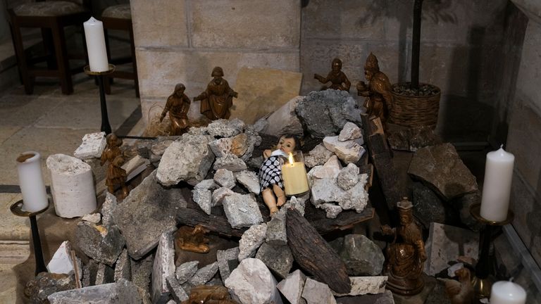 An installation of a scene of the Nativity of Christ with a figure symbolizing baby Jesus lying amid the rubble, in reference to Gaza, inside the Evangelical Lutheran Church in the West Bank town of Bethlehem, Sunday, Dec. 10, 2023. Pic: AP