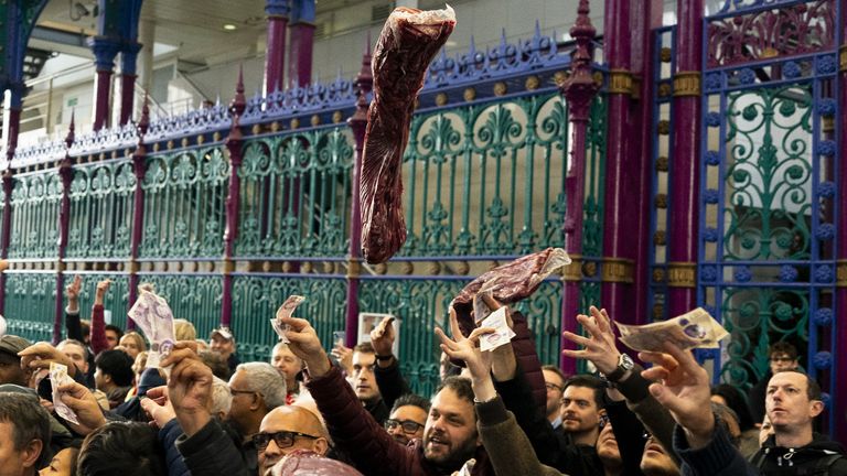Butchers of G Lawrence Wholesale Meats auction meat to event goers during the Smithfield Market Christmas meat auction in the market's Grand Avenue, in the City of London, as traders auction off their surplus meats to the public in a tradition that spans back a century. Picture date: Saturday December 23, 2023.