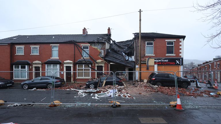 Debris litters the road and pavement in London Road, Blackburn, Lancashire, where a property collapsed just before 8pm on Sunday after an issue with gas triggered an explosion. Two people were taken to hospital and nearby properties have been evacuated. Picture date: Monday December 18, 2023. PA Photo. See PA story POLICE Blackburn. Photo credit should read: Paul Currie/PA Wire
