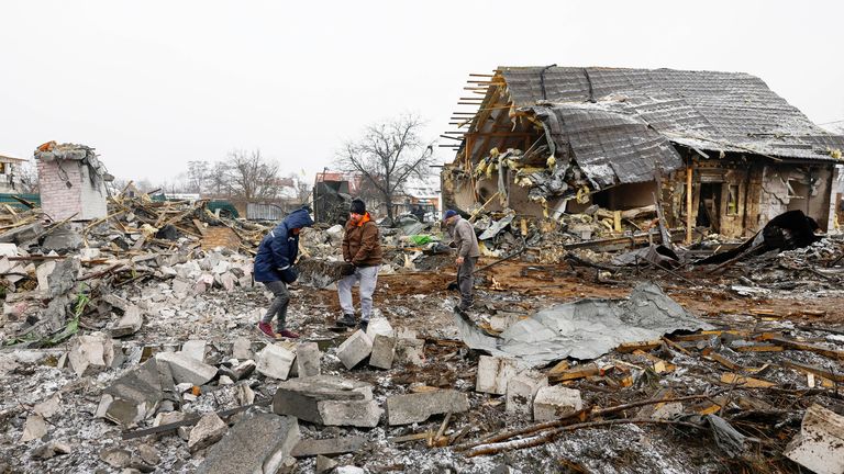 Local residents remove debris next to their neighbour&#39;s house, heavily damaged by a Russian missile strike, amid Russia&#39;s attack on Ukraine, in Kyiv, Ukraine December 11, 2023. REUTERS/Valentyn Ogirenko