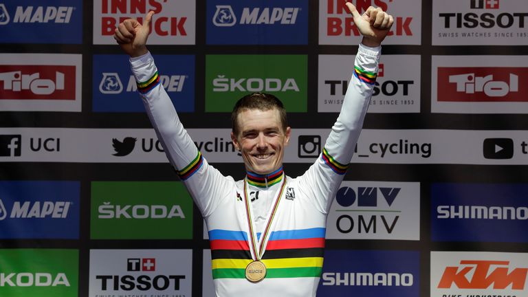 Dennis celebrates with his medal on the podium after winning the individual time trial event at the world championships in 2018