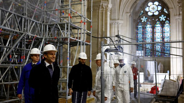 French President Emmanuel Macron, wearing a working helmet, arrives to visit the nave of the Notre-Dame de Paris Cathedral, which was ravaged by a fire in 2019 that sent its spire crumbling down, as restoration works continue a year before its reopening to the public, in Paris, France, December 8, 2023. REUTERS/Sarah Meyssonnier/Pool
