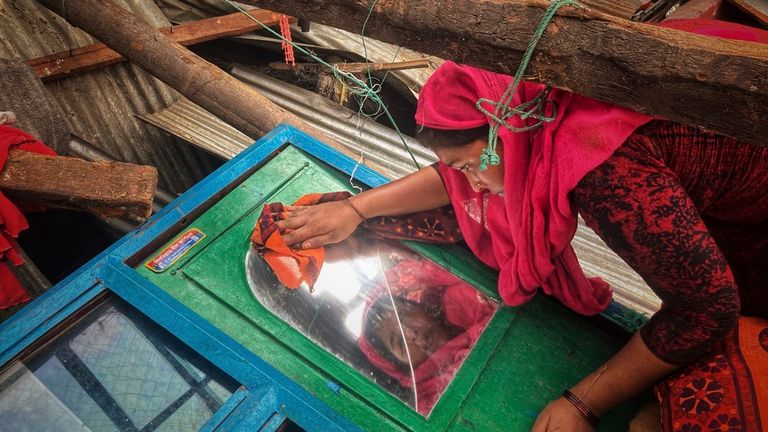 FILE - A woman salvages belongings from her home damaged by Cyclone Mocha at Saint Martin island in Cox&#39;s Bazar, Bangladesh, Monday, May 15, 2023.  The U.N. weather agency reported Monday that nearly 12,000 extreme weather, climate and water-related events over much of the last half-century around the globe have killed more than 2 million people and caused economic damage of $4.3 trillion. (AP Photo/Al-emrun Garjon, File)