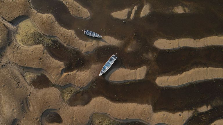 Canoes are seen at the dry riverbed of the Paraua river during a historic drought in the Amazon, in Careiro da Varzea, Amazonas state, Brazil October 26, 2023. REUTERS/Bruno Kelly