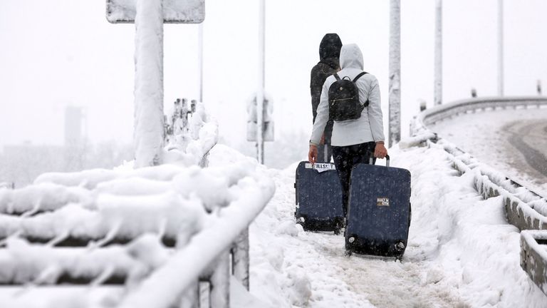 02 December 2023, Bavaria, Munich: Passengers walk through the snow with their suitcases on the airport grounds. The closure of flight operations at Munich Airport has been extended until 6 a.m. on December 3, 2023 due to heavy snowfall. Photo by: Karl-Josef Hildenbrand/picture-alliance/dpa/AP Images