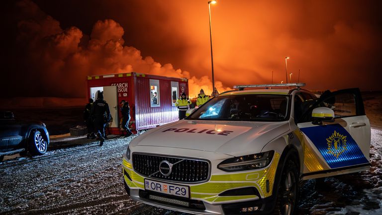 The police vehicle is parked at the entrance of the road to Grindavik with the eruption in the background, near Grindavik on Iceland&#39;s Reykjanes Peninsula, Monday, Dec. 18, 2023. A volcanic eruption started Monday night on Iceland&#39;s Reykjanes Peninsula, turning the sky orange and prompting the country&#39;s civil defense to be on high alert. (AP Photo/Marco Di Marco)