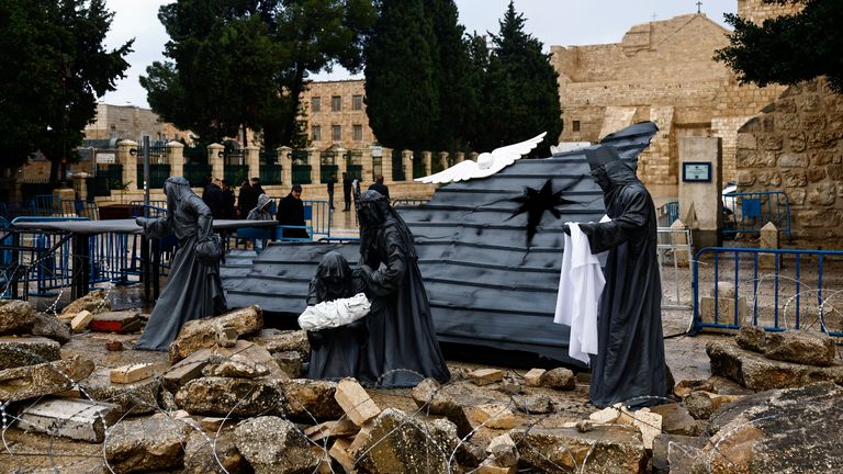 A Christmas installation of a grotto with figures standing amid rubble surrounded by a razor wire, is displayed outside the Church of the Nativity, in support of Gaza, on Manger Square in Bethlehem, in the Israeli-occupied West Bank December 24, 2023. REUTERS/Clodagh Kilcoyne
