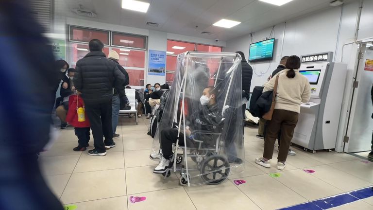A wheelchair user with a plastic covering, as patients take extra precautions while they wait for treatment 
