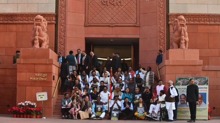 Indian lawmakers sit on the stairs of the parliament building in protest against the suspension of lawmakers, in New Delhi, India. Pic: AP