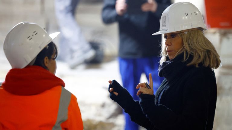 Brigitte Macron talks with a worker as she visits the nave of Notre-Dame