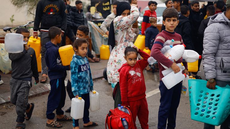 Palestinian children queue to collect water in Rafah