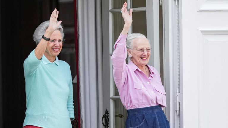 Queen Margrethe and her sister Princess Benedikte wave to the public while watching changing of the guard at Graasten Castle in July