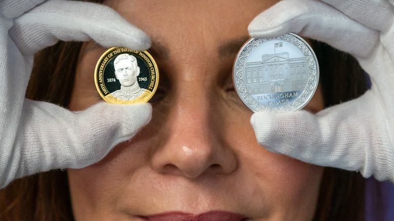 The Royal Mint&#39;s director of commemorative coins, Rebecca Morgan, holding the Winston Churchill £2 and the Buckingham Palace £5 coins for 2024