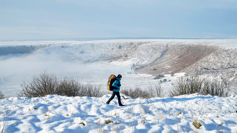 A person walks through snow above the Hole of Horcum at the North York Moors National Park, as scattered weather warnings for snow and ice are in place across the UK as temperatures plunged below freezing overnight. The Met Office has issued yellow warnings through Saturday morning for the northern coast and southwest of Scotland, as well as southwest and the eastern coast of England. Picture date: Saturday December 2, 2023.